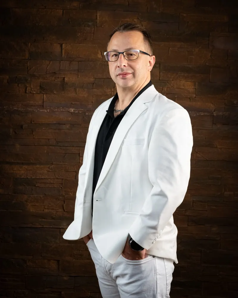 Business Portrait im Halbprofil vor Backsteinwand