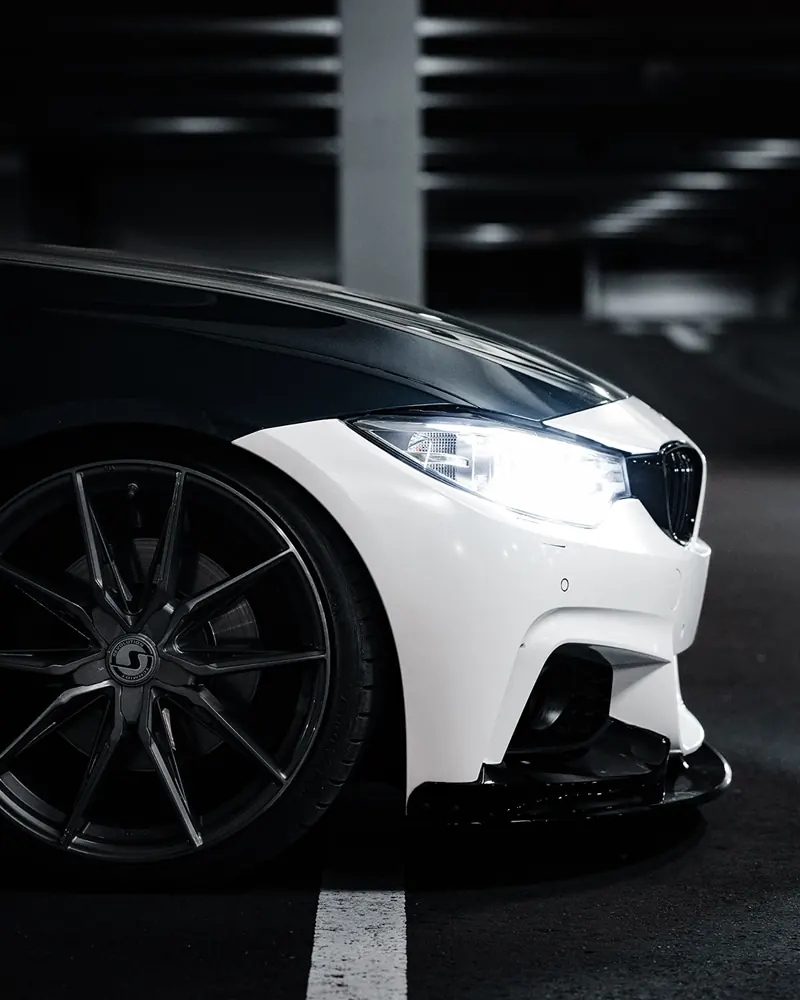 Felgendetail eines weißen BMW in dunkler Umgebung