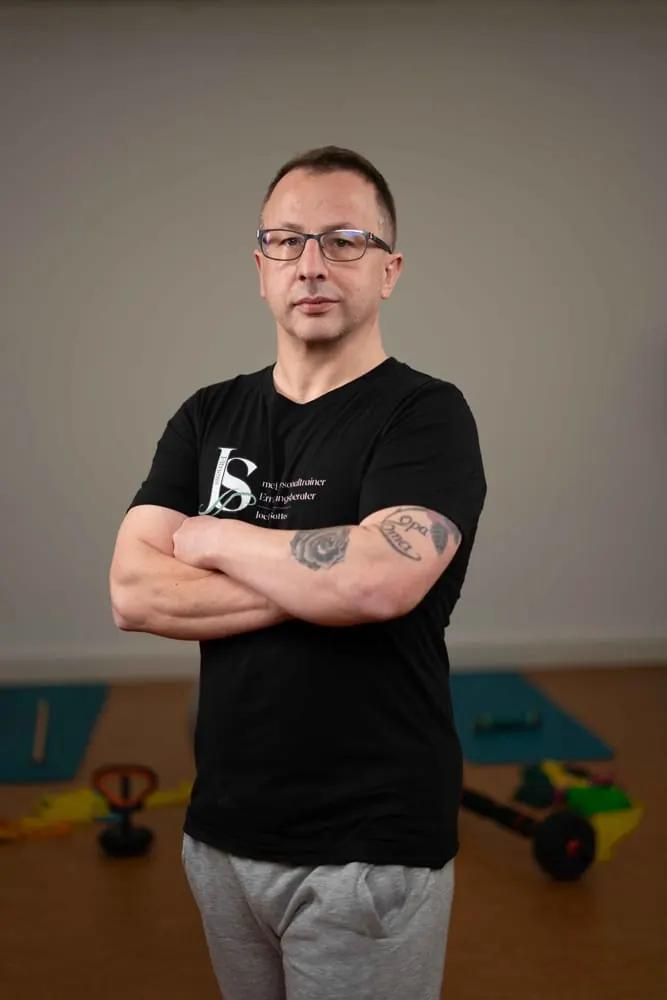 Portrait eines Fitnesstrainers mit verschränkten Armen