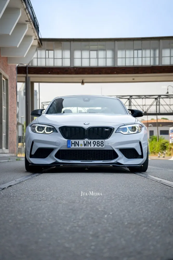 Hellblauer BMW M2 vor historischer Industriehalle
