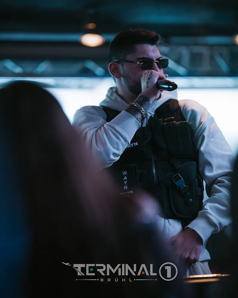 Künstler mit Mikrofon im Bühnenlicht des Terminal 1