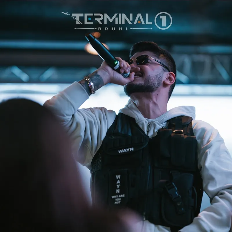 Rapper mit Mikrofon auf der Bühne im Scheinwerferlicht