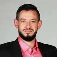 Business Portrait: Mann im dunklen Sakko mit rosafarbenem Hemd